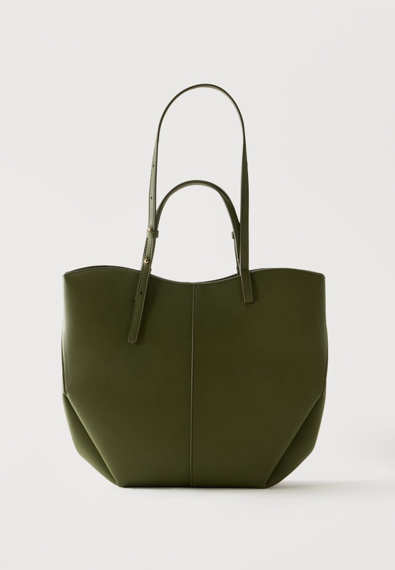 Sac cabas vert olive avec deux longues anses, corps structuré, lignes épurées et texture lisse sur un fond clair uni.
