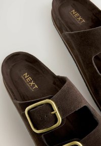 Sandalias de ante marrón tipo slide con hebillas cuadradas en tono dorado y plantillas acolchadas de la marca "NEXT Forever Comfort."