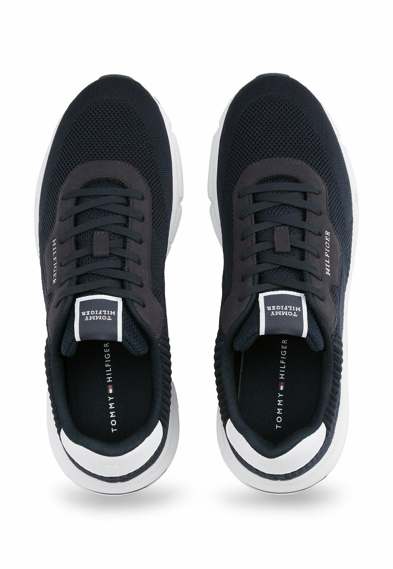 Zapatillas de malla navy con punta redonda, cordones negros y detalles en la suela blanca. Presentan un logotipo en la lengüeta y en los paneles laterales.