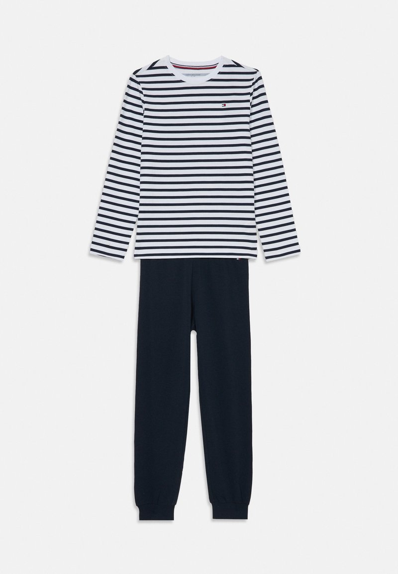 Striped long-sleeve top in white and navy with round neckline paired with solid navy trousers featuring elastic cuffs. Soft cotton fabric.
