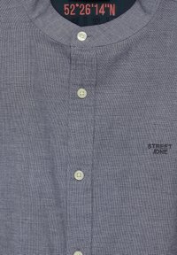 Camicia button-up di un blu navy scuro con motivo a piccoli quadretti, scollo rotondo e bottoni bianchi. Presenta il logo "STREET ONE" in nero.