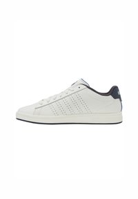 Weiße Leder-Sneaker mit einer glatten Textur, die über perforierte Seitenakzente, eine marineblaue Fersenpartie und eine Gummisohle verfügen. Die Schnürsenkel sind im klassischen Design.