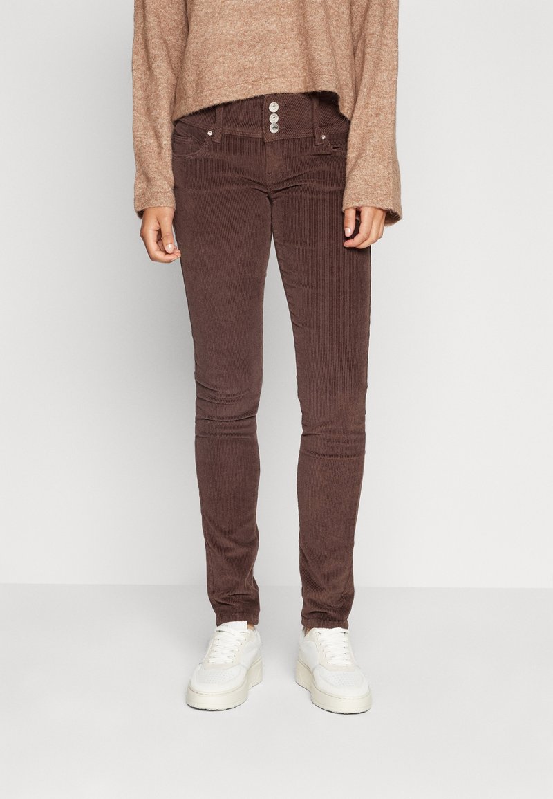 Hnědé kordové skinny džíny s vysokým pasem, které mají tři knoflíky, dvě přední kapsy a strukturovanou tkaninu.