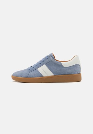 Suede low-top sneaker in light blue with white stripes, rubber sole, round toe, and contrasting tan accents on the sole and interior.
