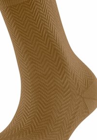 Braune Socken mit Fischgratmuster, aus strukturiertem Material gefertigt. Das Design umfasst eine glatte Oberfläche mit einer passgenauen Form.