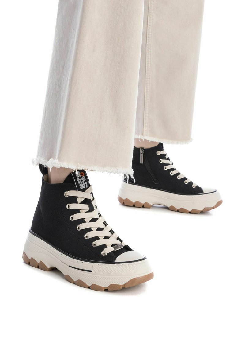Sneaker alte nere con tomaia in cotone, lacci crema, punta in gomma e suola chunky beige con un motivo testurizzato.