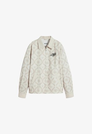 Beige színű, cipzáras dzseki, világos taupe mintázatú formákkal. Oldalsó zsebekkel rendelkezik, és fekete hímzett logó található a mellkasán. Puha anyagból készült.