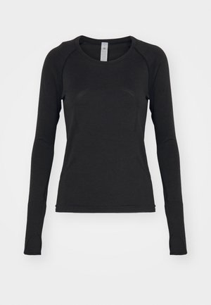 Chemise à manches longues noire, fabriquée en tissu doux. Présente un col rond et des manches raglan avec des ouvertures pour les pouces au niveau des poignets. Design minimaliste.