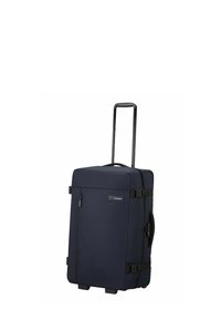 Valise à roulettes bleu marine en tissu texturé, équipée d'une poignée rétractable, d'une poche latérale et de sangles à boucle pour une fermeture sécurisée.