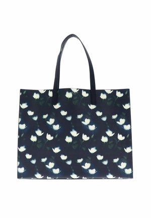 Sac fourre-tout bleu marine avec motif floral blanc et deux longues poignées noires.
