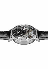 Automatisch uurwerk met een transparante kast, zwarte wijzerplaat, zilveren accenten, Romeinse cijfers als markeringen en een zwarte leren band met een geprofileerd patroon.