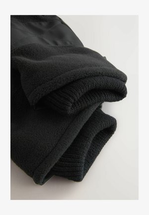 Czarna polarowa kurtka o miękkiej fakturze, z zagiętymi rękawami i gładką tkaniną na panelu. Prosty i funkcjonalny design.