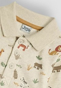 Béžová polo košela s vzorom zvierat, so svetlohnedým golierom, tromi gombíkmi a štítkom s nápisom "JoJo." Bavlnená látka, ležérny dizajn.