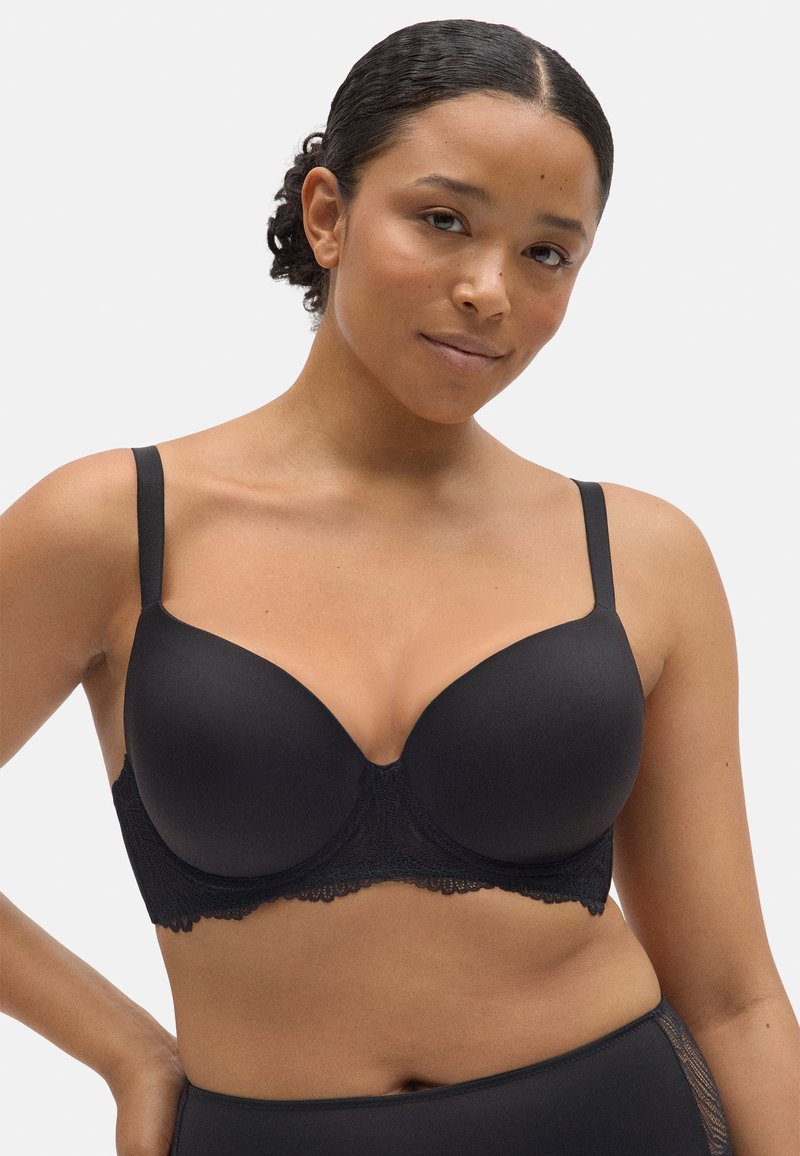 Bralette de lencería negra con copas moldeadas, tirantes ajustables y detalles de encaje a lo largo de la banda. Textura suave con un diseño sin costuras.