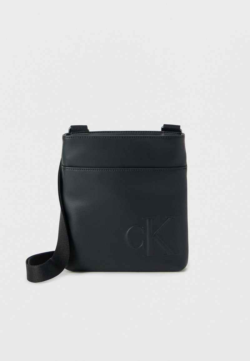 Μαύρη δερμάτινη τσάντα χιαστί με ανάγλυφο λογότυπο «cK», λεία υφή, ρυθμιζόμενο λουράκι και μπροστινή τσέπη για επιπλέον αποθήκευση.