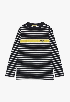 Czarna i biała, poziomo paskowana koszula z długim rękawem, z żółtym poziomym paskiem na wysokości klatki piersiowej z napisem „AMS SCOTCH”.