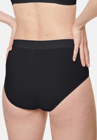 Schwarze Baumwolle-Höschen mit hohem Bund, glatter Textur und elastischem Bund. Verfügt über gewellte Kanten entlang der Beinöffnungen.