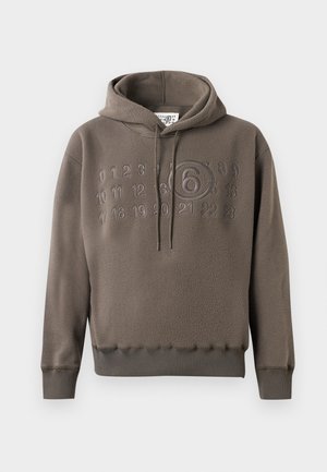 Haut à capuche en polaire marron avec des chiffres en relief de 0 à 23 sur la poitrine, présentant un grand chiffre 6 encerclé au centre.