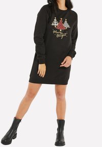 Robe sweat-shirt noire à manches longues, présentant des graphismes colorés d'arbres de Noël et le texte "Joyeux et Radieux" en or. Matière douce en mélange de coton.