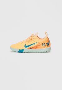 Zapatillas deportivas naranjas y amarillas con un swoosh de Nike turquesa, parte superior texturizada y un patrón que transita a un naranja oscuro, con una suela verde clara.