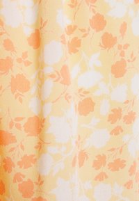 Květinová látka v žluté barvě, zdobená oranžovými a bílými květy na texturovaném pozadí. Design zahrnuje listy proložené květy.