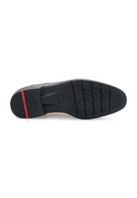 Semelle de chaussure avec une surface en caoutchouc noir, présentant un design texturé pour l'adhérence, et une bande d'accent rouge à l'arrière.