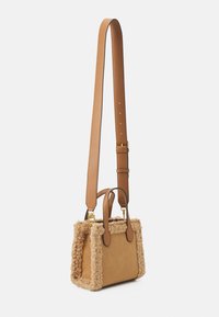 Bruine leren tas met schapenfleece-afwerking, rechthoekige vorm, korte handvatten aan de bovenkant en verstelbare schouderriem. Accenten van goudkleurig metaal.