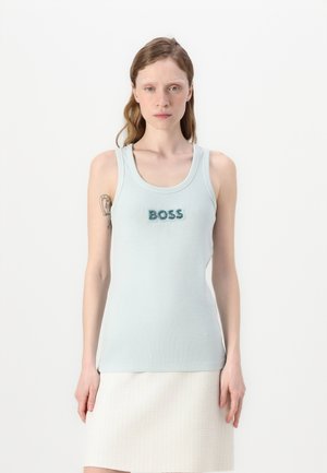 Svetlo modra brezrokavna majica z ribasto strukturo in zaobljenim ovratnikom. Ponuja besedo "BOSS" v temno modri okrasni barvi.