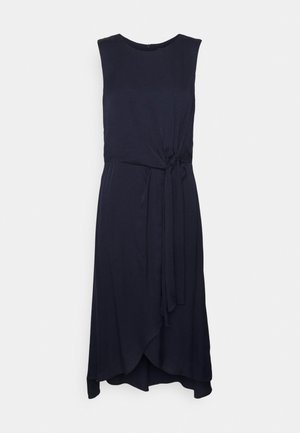 Vestido sem mangas azul-marinho com decote redondo, detalhe de laço na cintura e uma bainha assimétrica. Feito de um tecido suave e fluido.