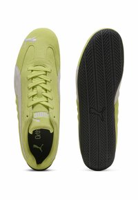 Zapatillas de ante verde lima con detalles en blanco, con un diseño de cordones y suela de goma texturizada negra. Detalle del logo en la lengüeta.
