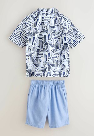 Camisa blanca de manga corta con patrón de laberinto azul marino y pantalones cortos de cintura elástica azul claro, colocados planos sobre un fondo neutro.