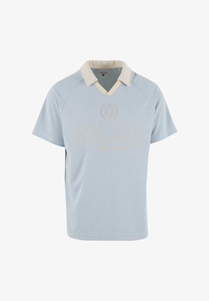 Világoskék rövid ujjú galléros póló krémszínű gallérral, függőleges vékony csíkokkal és krémszínű "KARL KANI" hímzett logóval.