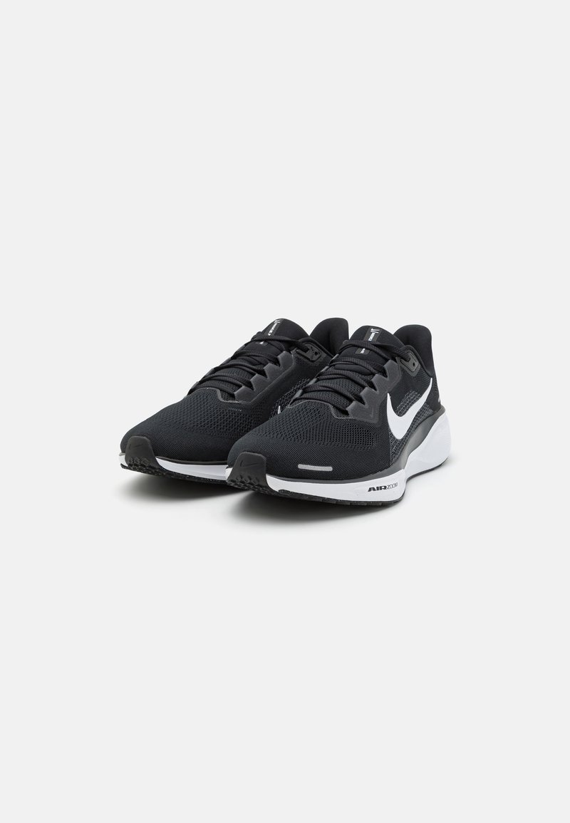 Zapatillas deportivas negras con parte superior de malla transpirable, acentos en blanco, suela acolchada y suela de goma para tracción. Incluyen cordones y cuello acolchado.
