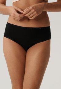 Czarne bawełniane majtki hipstery o gładkiej fakturze, elastycznym pasie i małym logo z boku po lewej stronie.