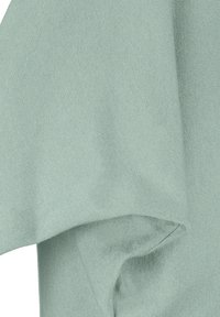 Hellgrüner Stoff mit weicher Textur, der eine glatte Oberfläche und subtile Rippdetails aufweist, an den Kanten gefaltet.