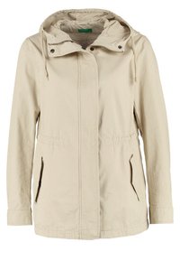 Beige lättviktsjacka med huva. Har sidofickor, framknäppning med tryckknappar och dragsko vid huvan och midjan. Slät textur.