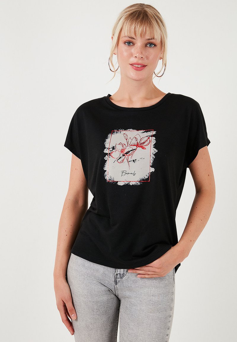 Zwarte T-shirt met korte mouwen met een bloemenprint in rood en wit op een textuur achtergrond. Ronde halslijn, relaxte pasvorm.