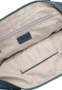 Vidinė užsegama krepšelio dalis iš smėlio spalvos audinio su lygiu paviršiumi, turinti mažą užtrauktuku užsegamą kišenėlę ir audinio žymeklį su mėlynos spalvos siūlėmis.