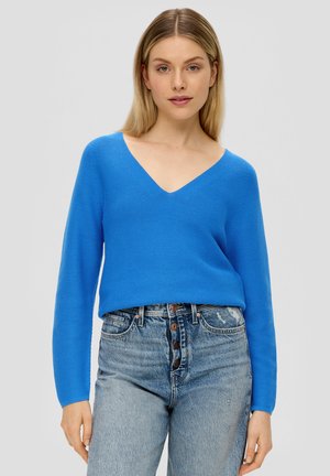Helderblauwe, getextureerde gebreide sweater met een V-hals, lange mouwen en een relaxte fit, gecombineerd met lichtblauwe denim jeans met hoge taille.