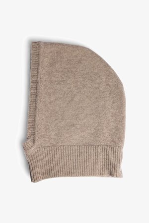 Beige knit beanie with a soft texture. Features a folded brim and an elongated design, made from warm fabric suitable for colder weather.