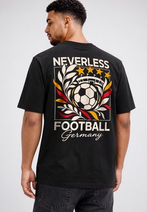 Mann mit dem Rücken zur Kamera, trägt ein schwarzes T-Shirt mit buntem Fußball-Design, Sternen und dem Text "Neverless Football Germany" auf dem Rücken.