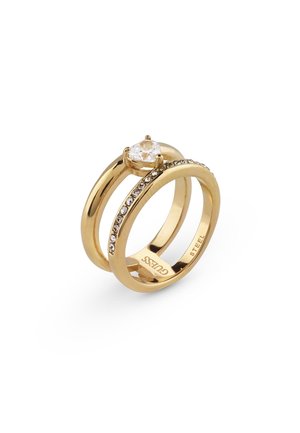 To guldringe, den ene med en stor klar ædelsten og den anden med en række små klare sten langs ringen, mærket "GUESS."