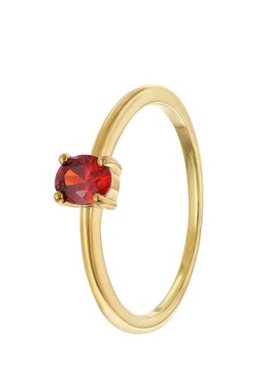 Goldener Ring mit einem einzelnen ovalen roten Edelstein, der in vier Krappen auf einem schlichten, polierten Band gefasst ist, vor weißem Hintergrund isoliert.