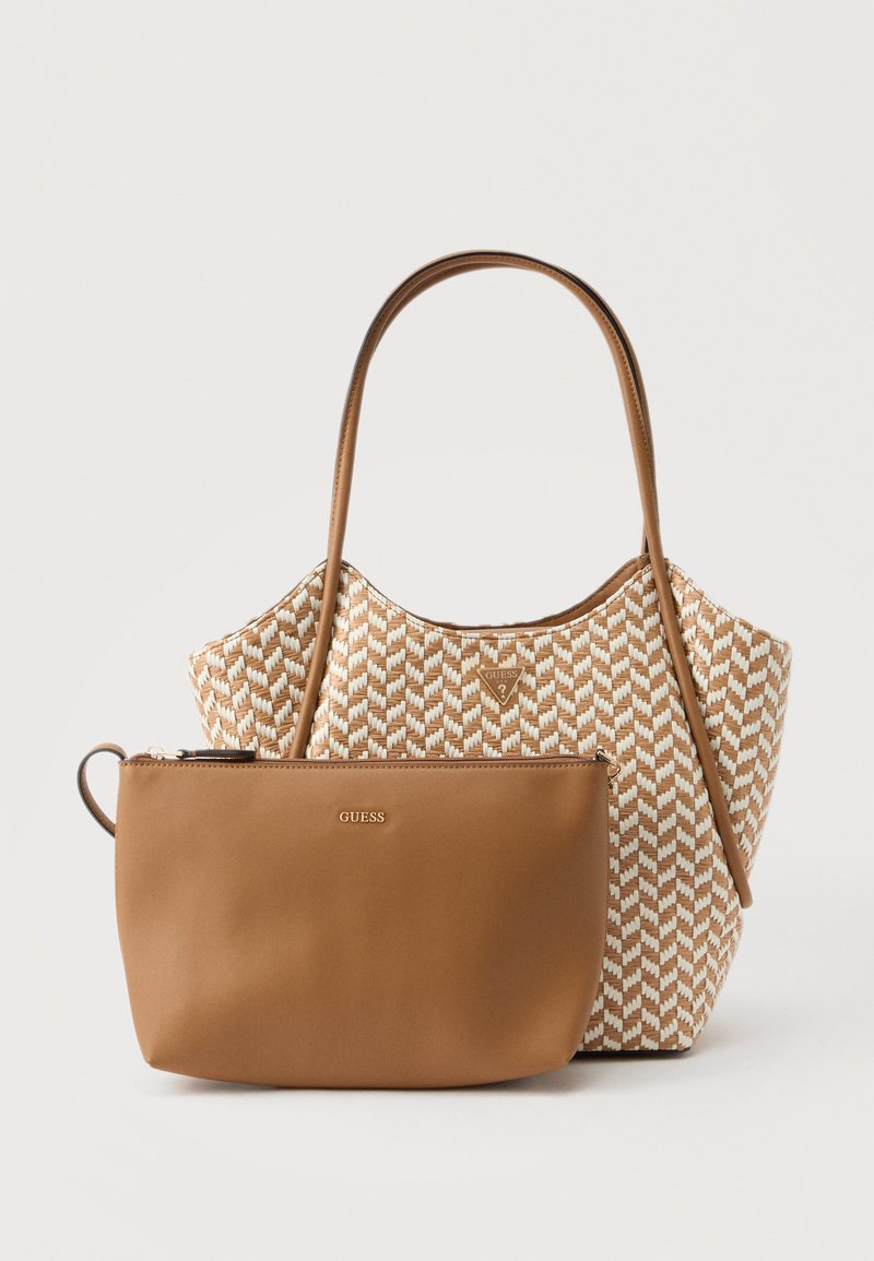 Sac fourre-tout en tissu tissé beige et blanc avec des poignées en cuir beige, accompagné d'une petite pochette en cuir lisse beige avec fermeture éclair et logo Guess.