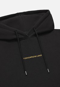 Zwarte hoodie gemaakt van een katoenmix. Voorzien van verstelbare koordjes met metalen uiteinden en het 'TOMORROWLAND'-logo in gouden borduursel op de voorkant.