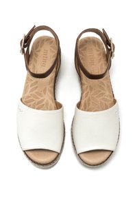 Sandalias de cuero blancas con una correa marrón en el tobillo, diseño de punta abierta y una plantilla texturizada con un patrón de hojas. Detalles de costura a lo largo de los bordes.