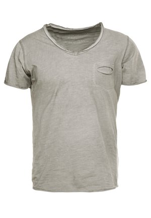 T-shirt grigia in cotone con scollo a V, maniche corte, tasca frontale con ritaglio ovale e vestibilità morbida. La texture appare liscia e leggera.