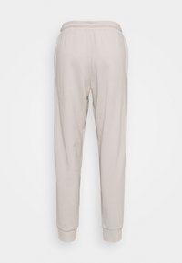 Light grey, cotton joggers with an elastic waistband, tapered legs, and cuffed hems. Smooth texture, no visible patterns or accents.