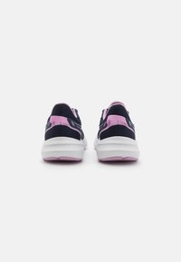 Baskets de sport bleu marine et rose avec une tige en mesh texturé, un talon rembourré et une semelle en caoutchouc blanche avec des accents roses.