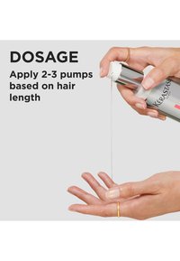 Kérastase hårbehandling i en pumpflaska av silver som doserar en klar vätska i en handflata. Guldring på fingrarna, enkel, modern design.